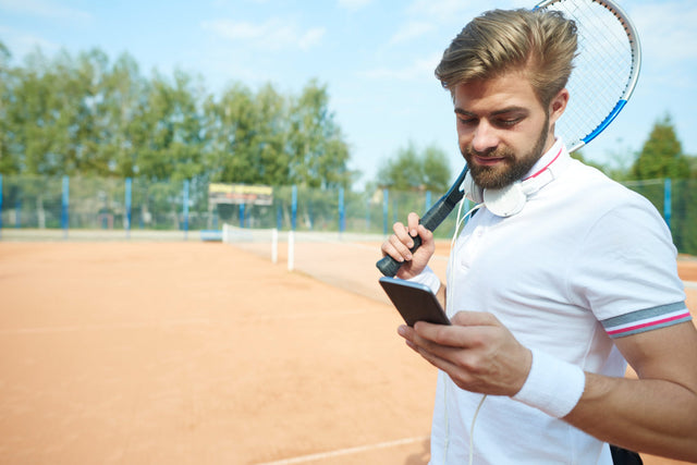 tennis player checking mobile phone